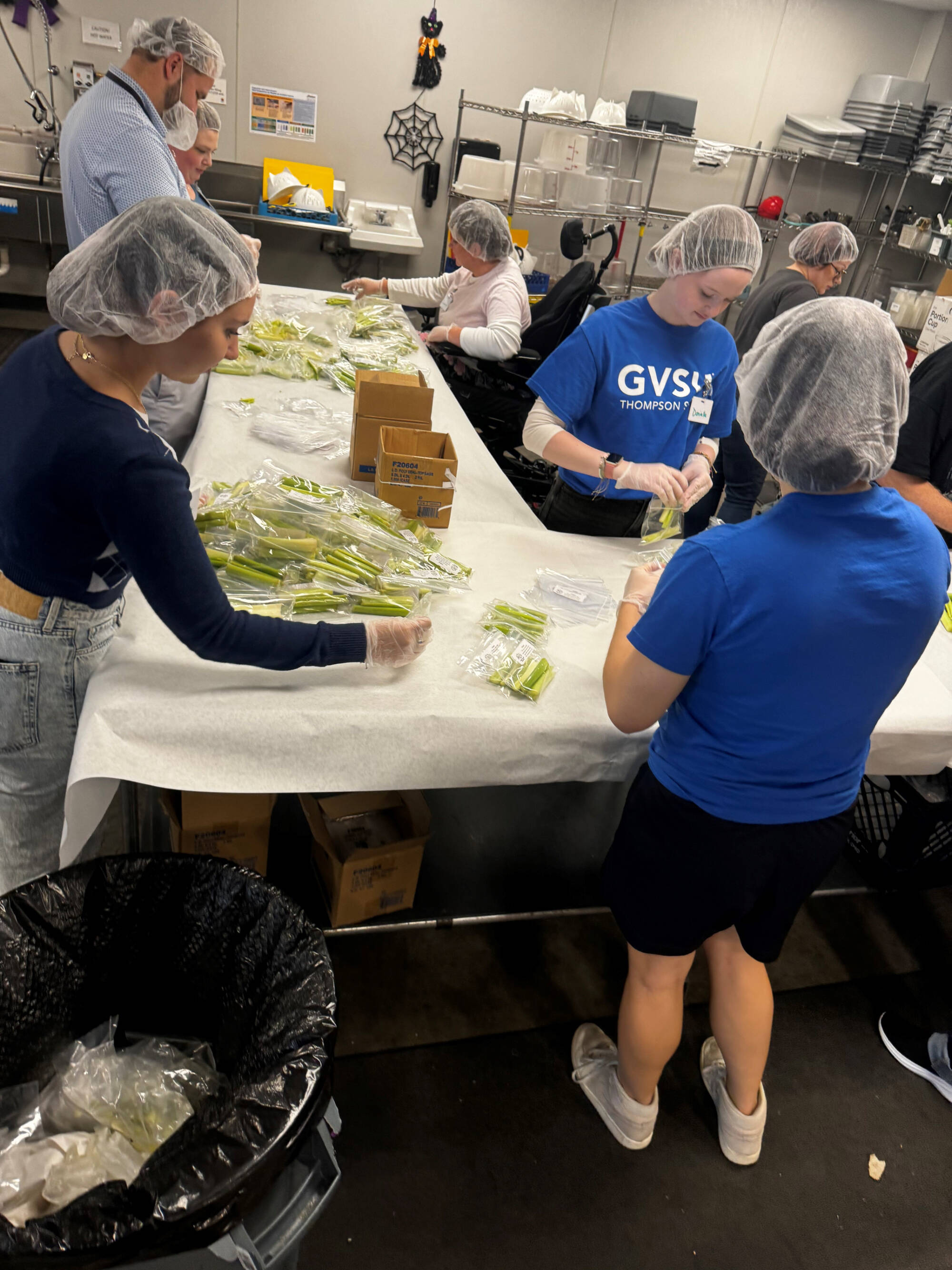 Students helping package meals at Kids Food Basket.